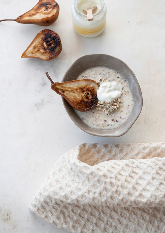 A cream waffle weave dish towel as part of a breakfast kitchen scene.