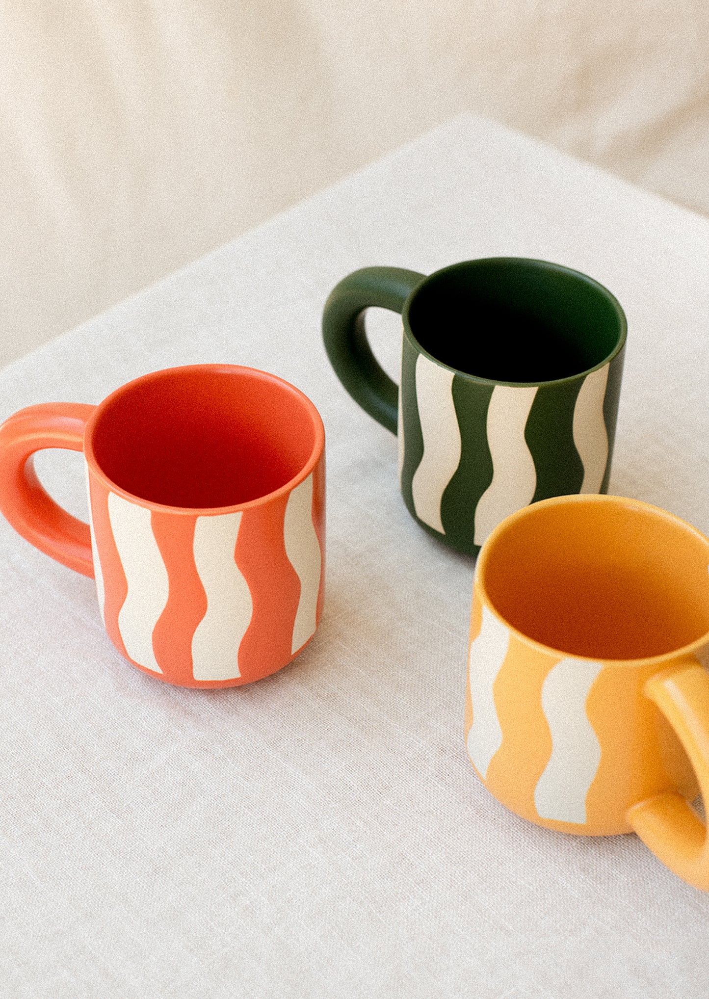 Colorful mugs with wax relief wavy stripes.