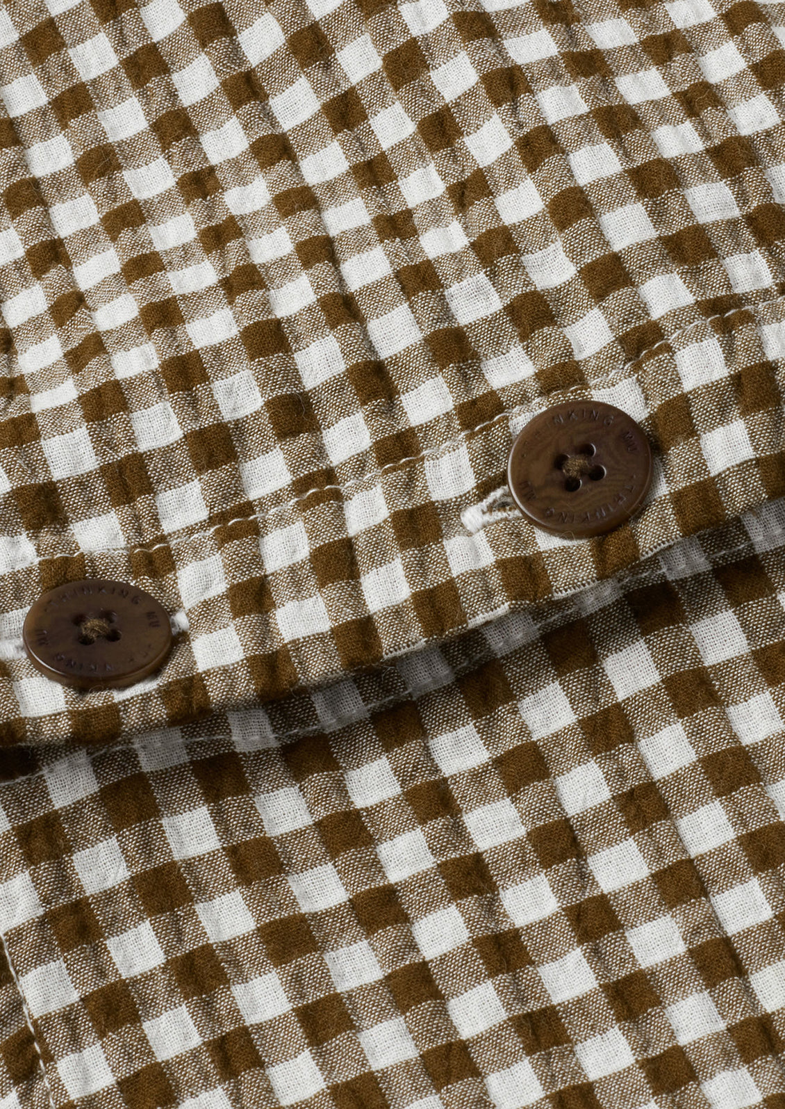 Brown and white textured gingham cotton fabric with brown button detail.