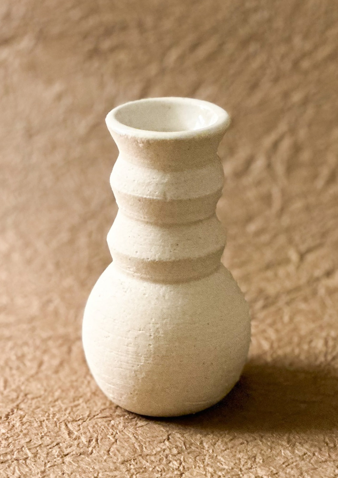 A sculptural, angular vase in white ceramic.