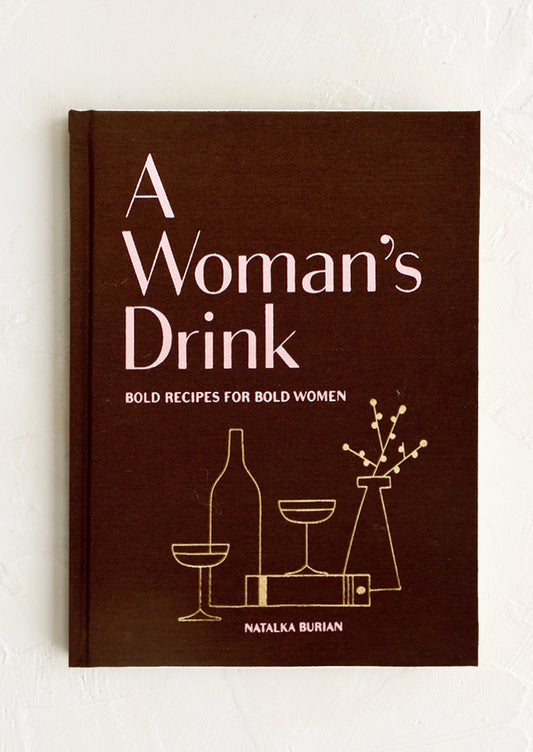 Front of a book with the text "A Woman's Drink" and line drawings of cocktails; pink on maroon.