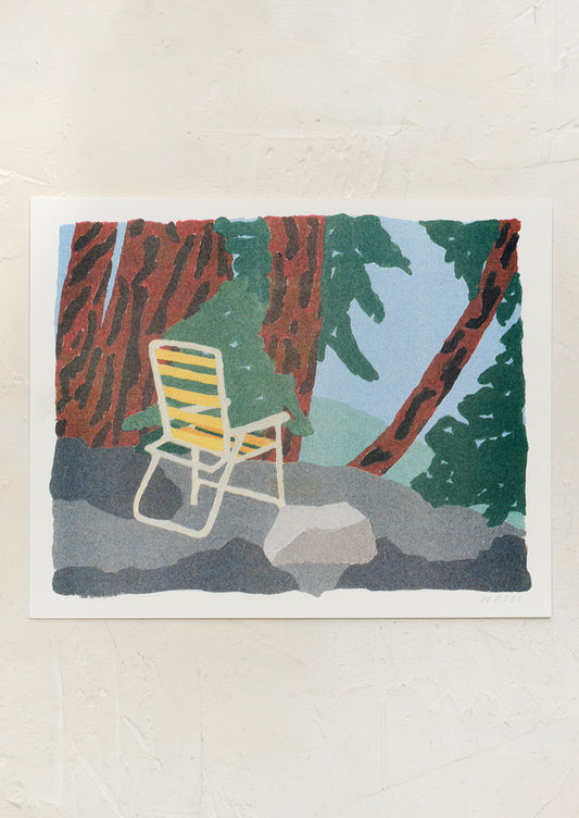 An art print of a yellow lawn chair amongst trees.