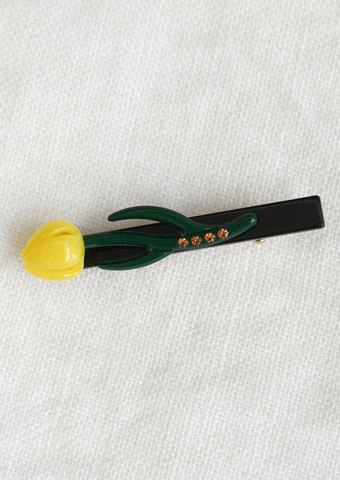 A tulip shaped barrette in yellow.