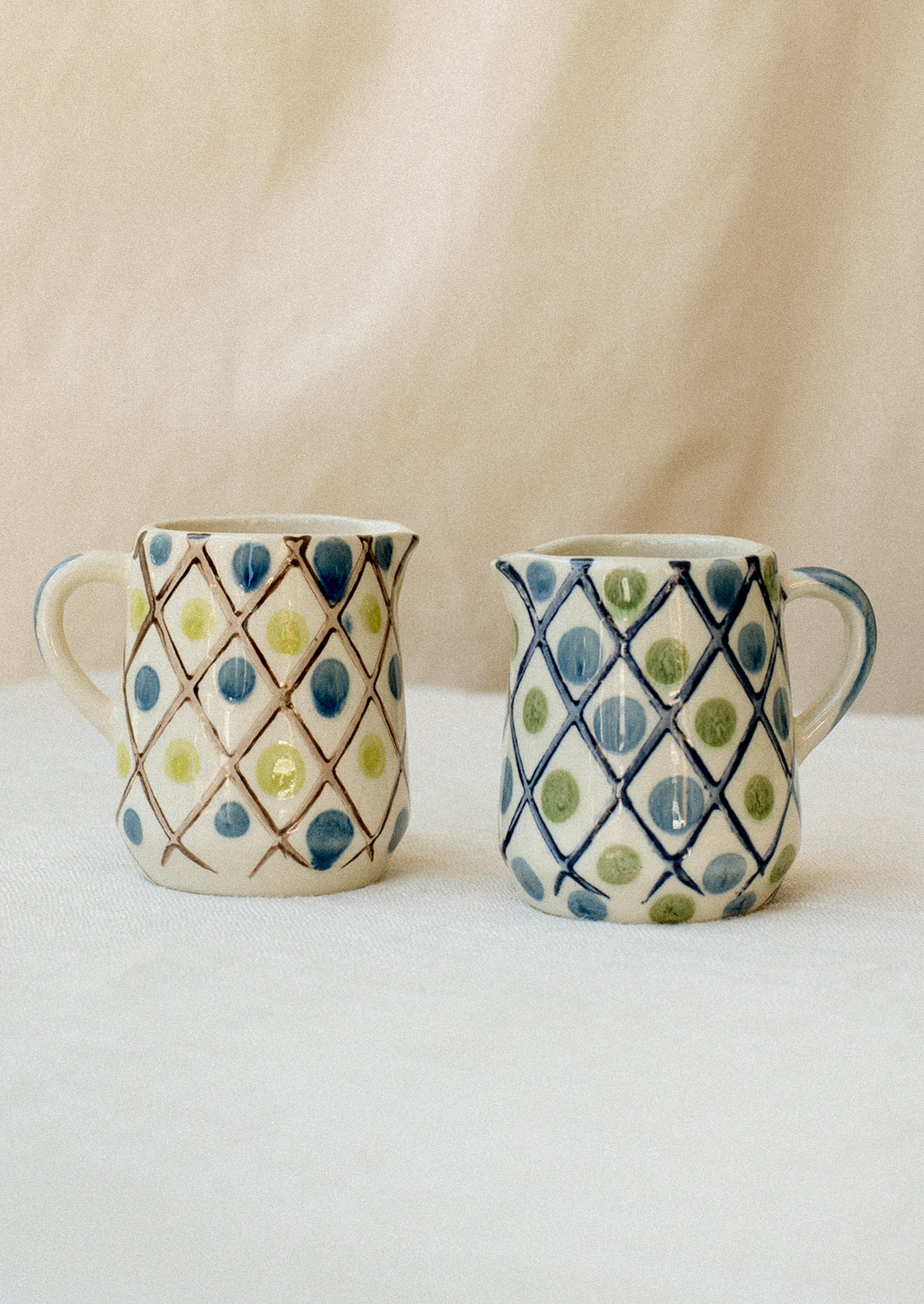 Small mini creamer pitchers in diamond and dot design.