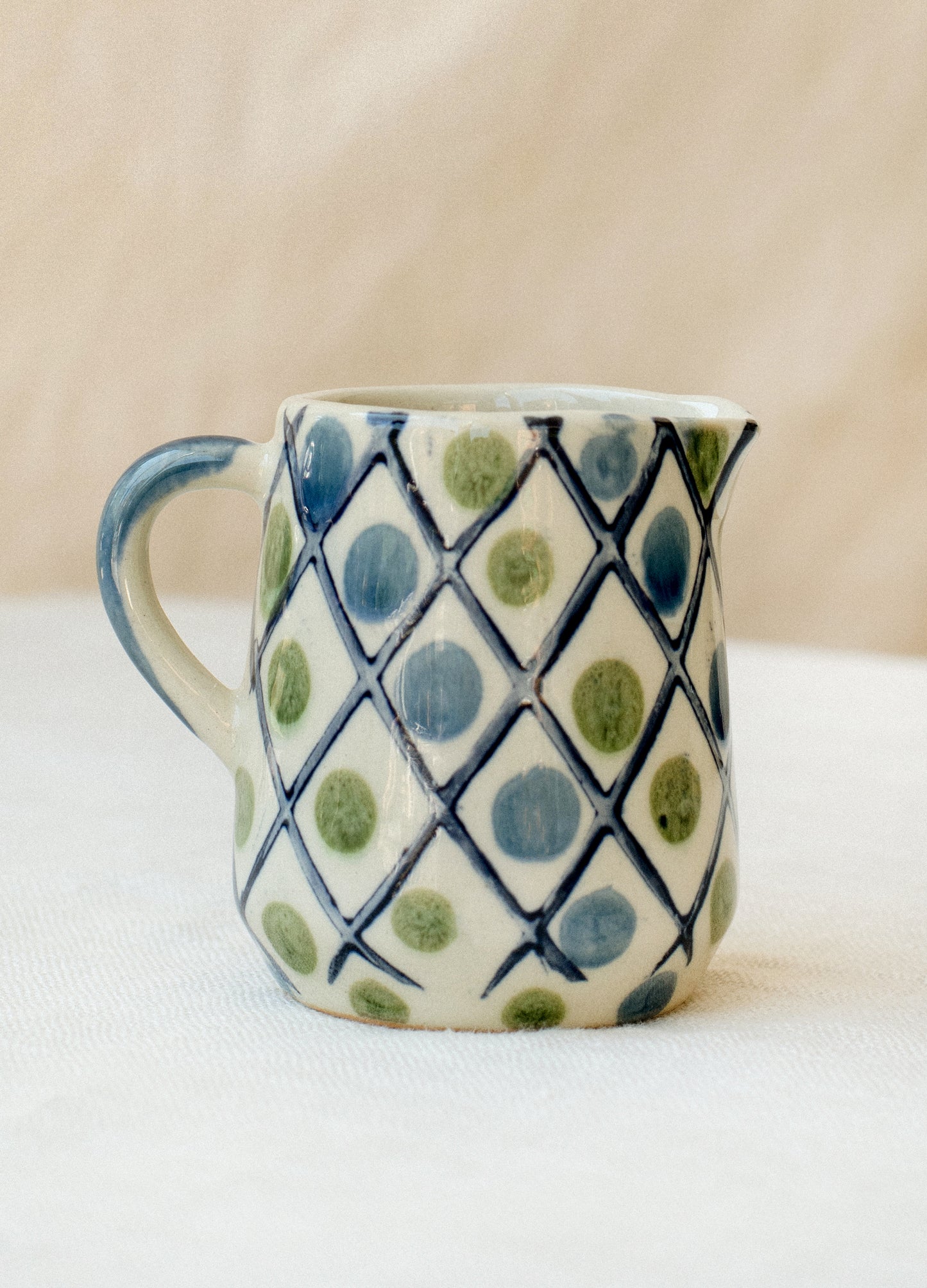 Small mini creamer pitchers in blue and green diamond and dot design.