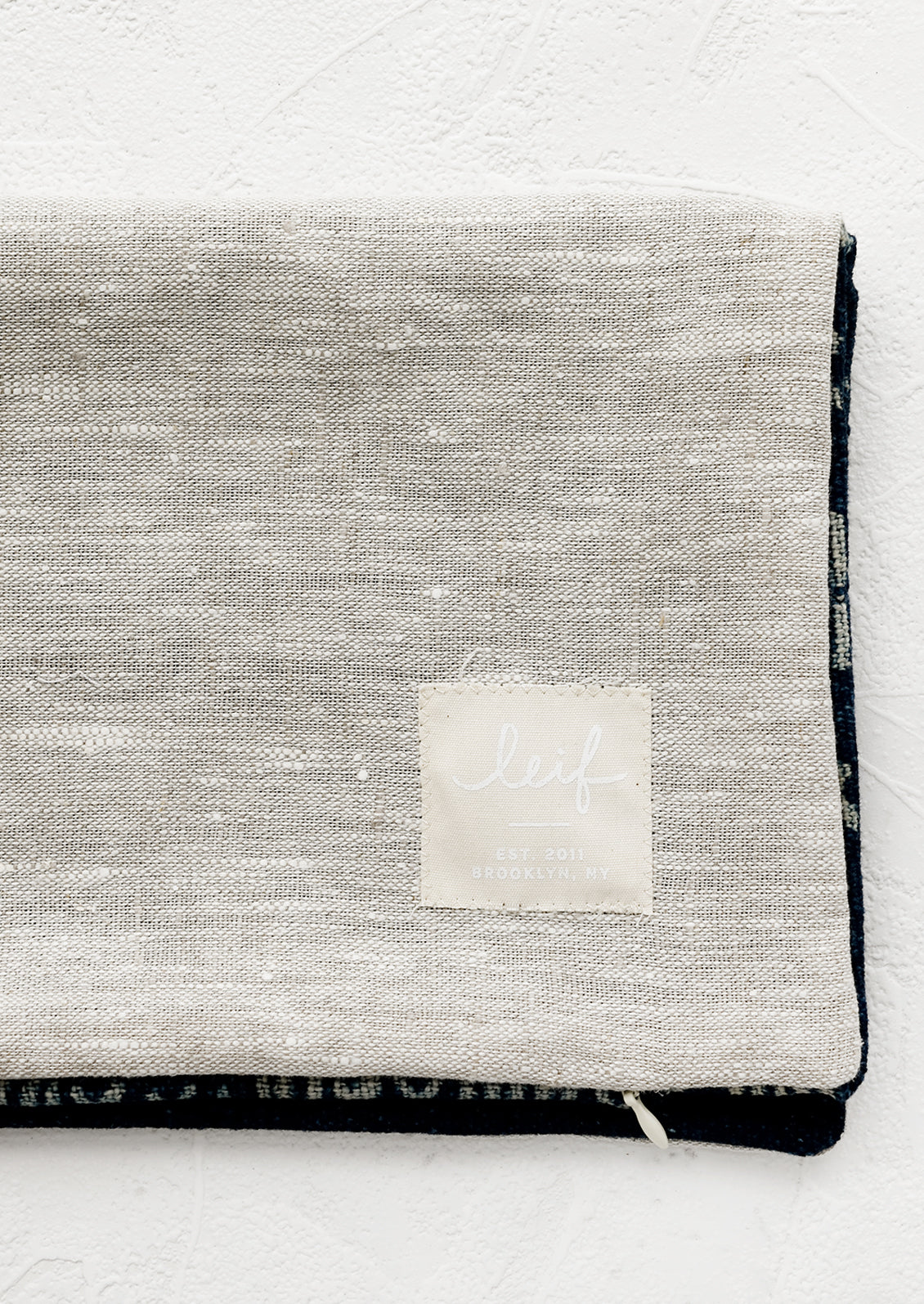 Natural linen pillow backing with logo patch.