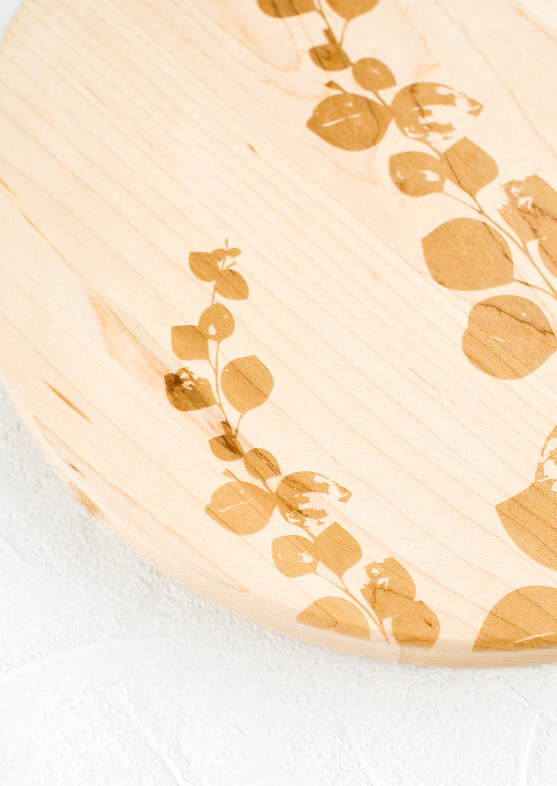 Botanical lasercut etched pattern on a maple wood cutting board.