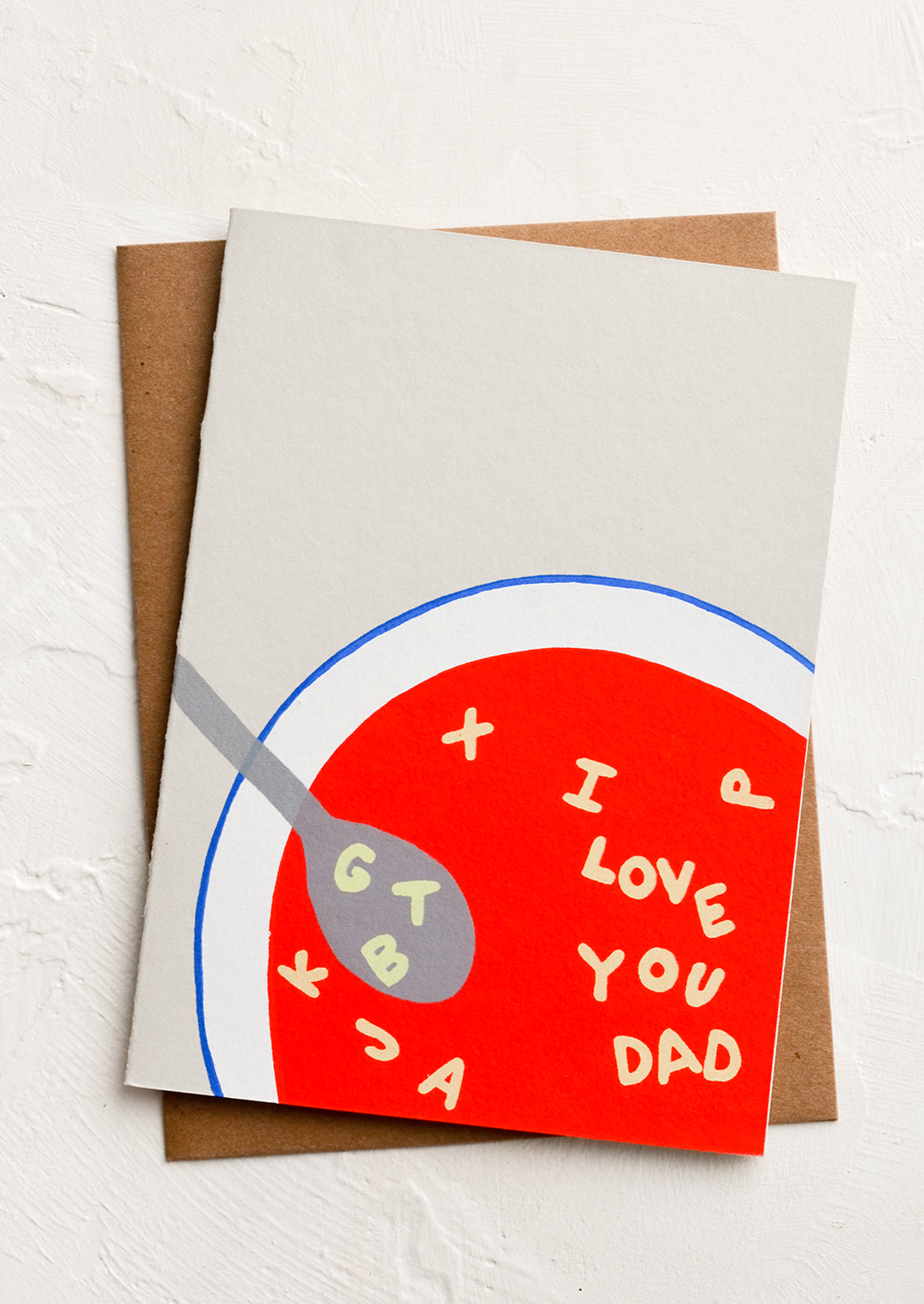 A greeting card with illustrated image of bowl of alphabet soup spelling "I love you dad".