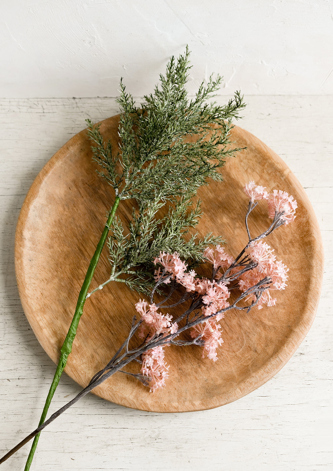 A round hardwood platter with flowers.