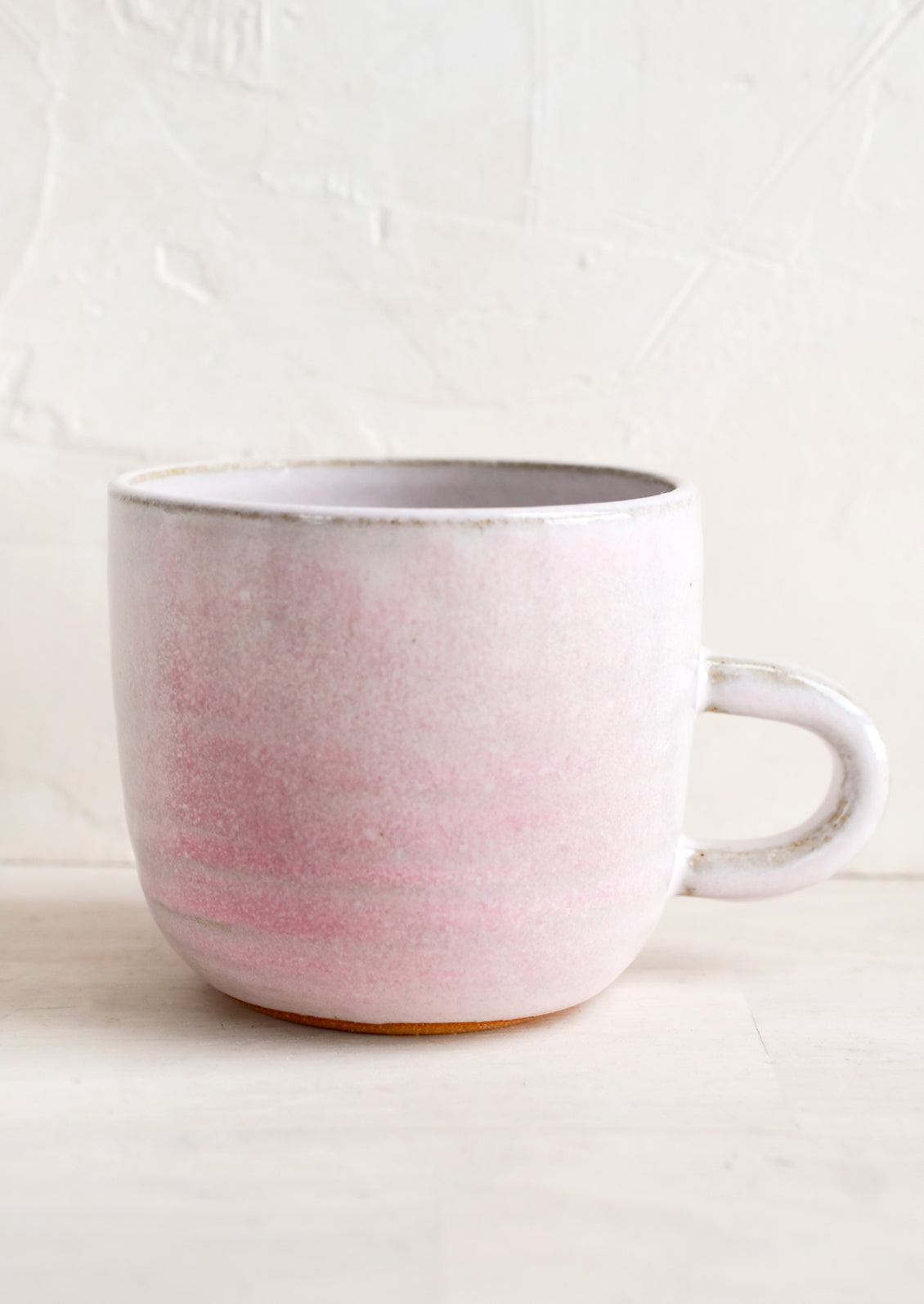 A short ceramic coffee mug in mottled lavender glaze.