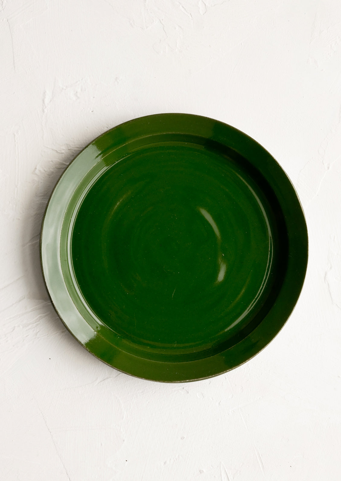 A ceramic side plate in glossy fern green glaze.