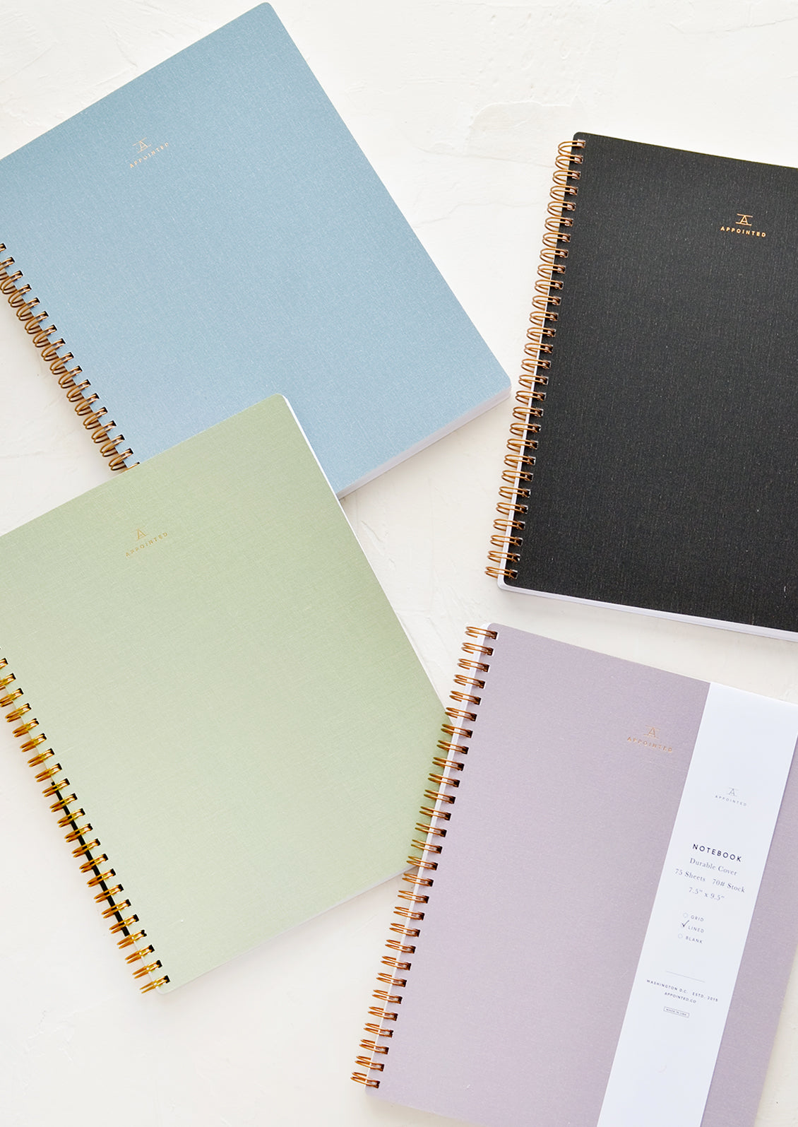 Four spiral bound notebooks in assorted colors.