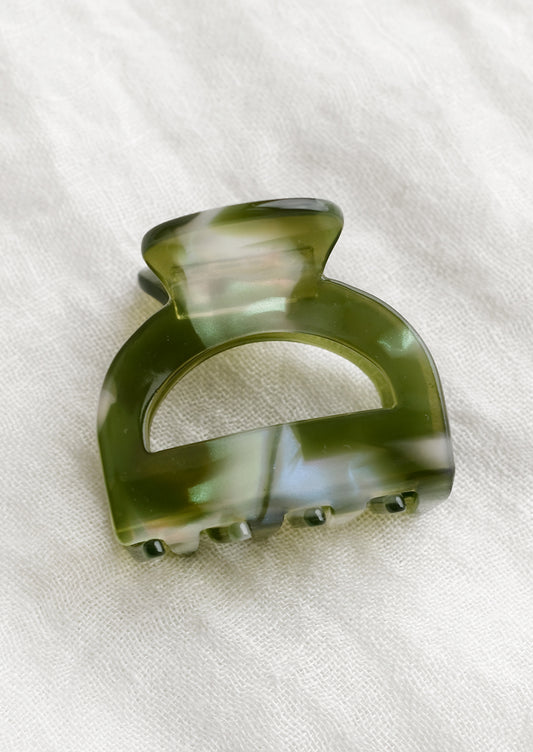 An arch shaped hair claw in olive pearl.