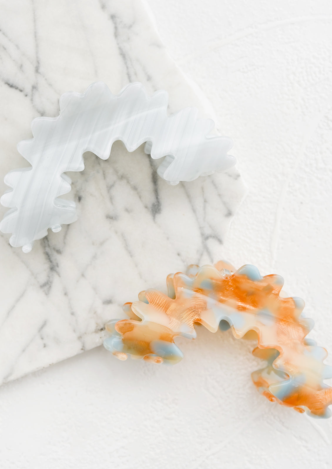 Arched squiggle hair claws in blue and orange.