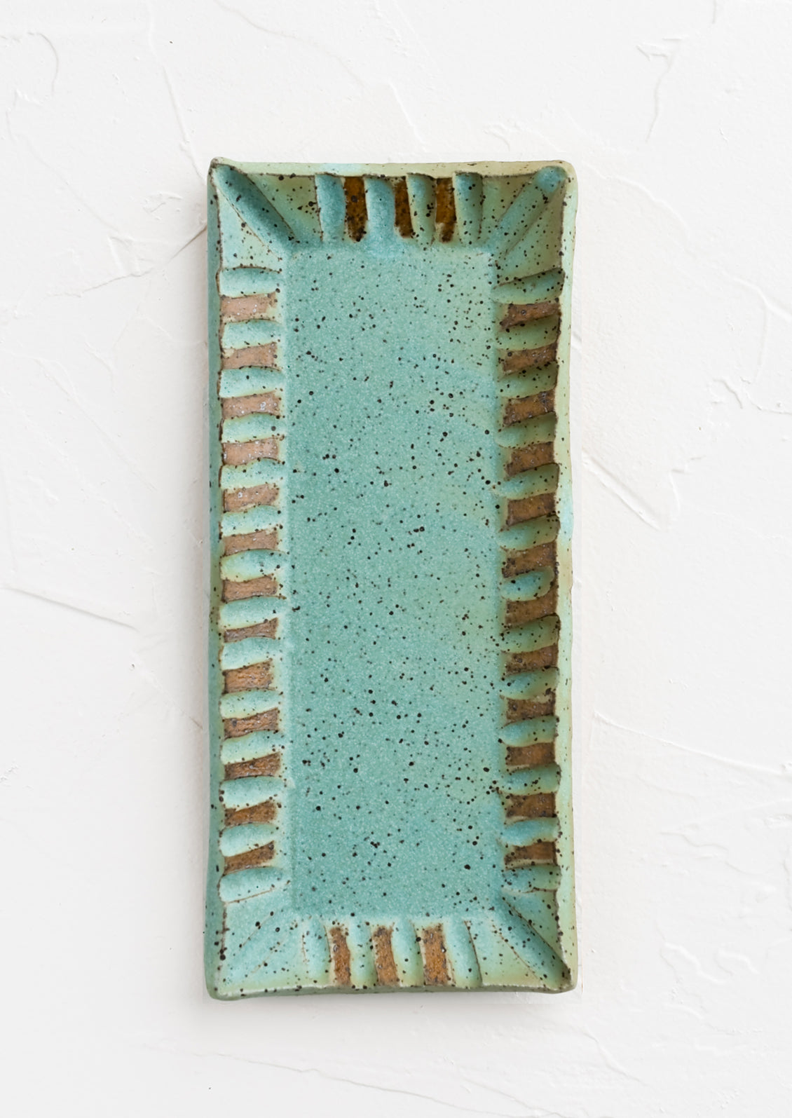 A rectangular ceramic butter dish with textured border in turquoise speckle.