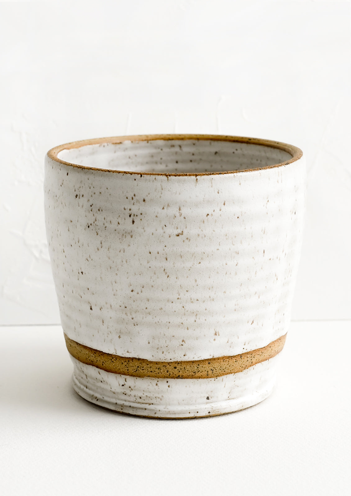 A ceramic utensil holder in white speckle.