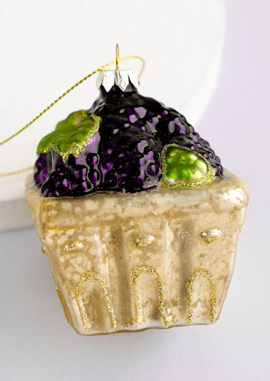 A glass ornament of blackberries in a produce basket.