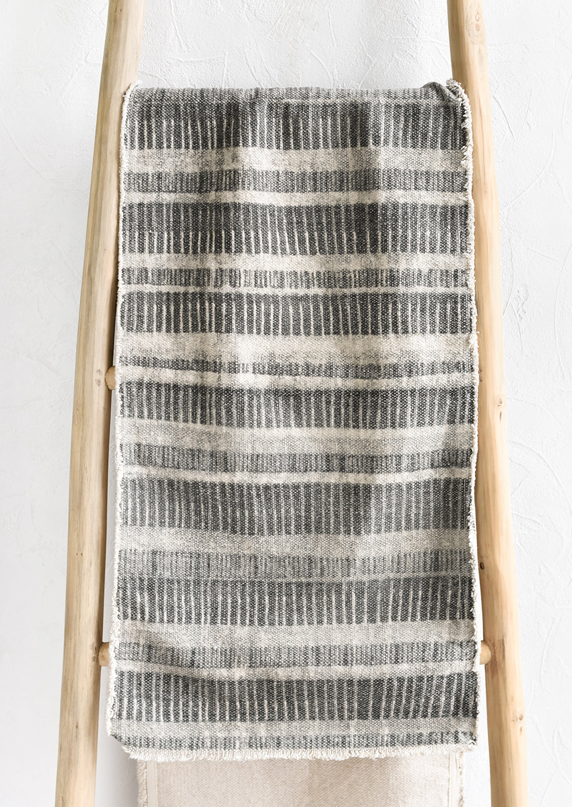 A table runner in grey stripe print.