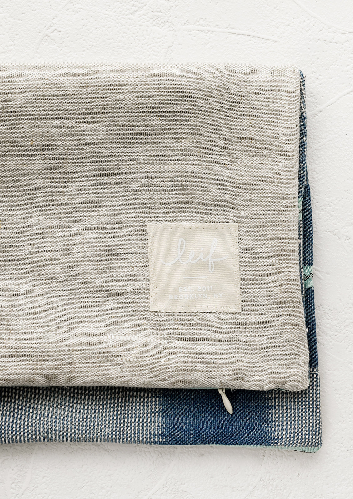 Natural linen pillow backing with logo patch.