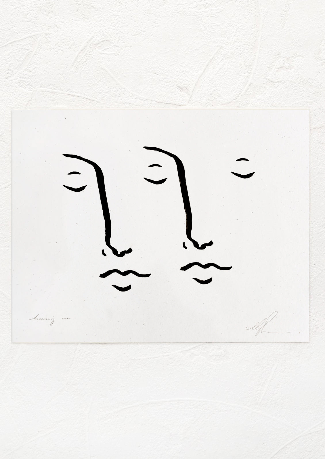 A black and white art print with drawing of two faces together.