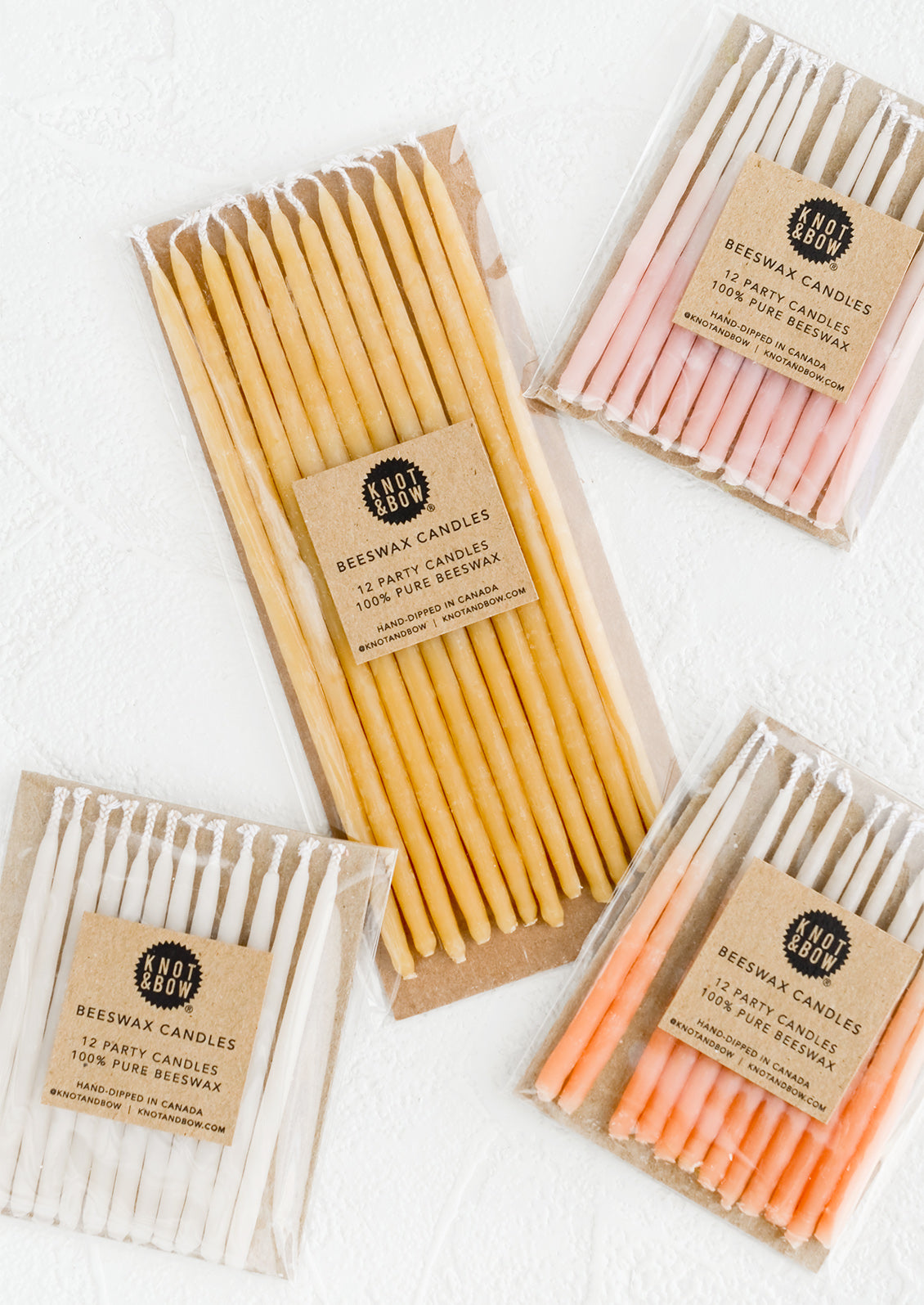 Packages of beeswax birthday candles in a mix of colors and sizes.