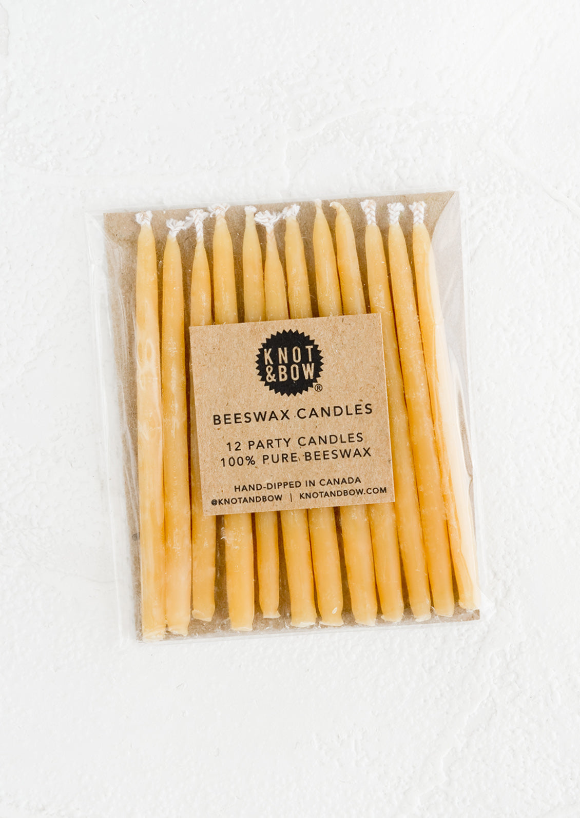 A package of 12 short natural beeswax birthday candles.