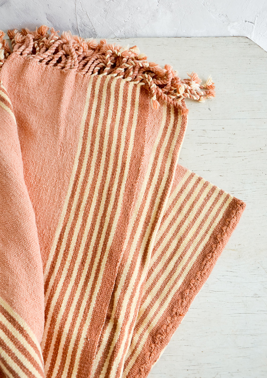 Natural woven cotton throw in beige and terracotta stripes with twisted fringe edge