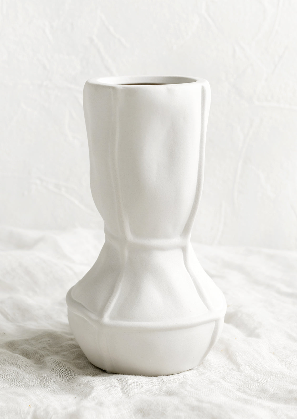 A tall geometric vase in matte white ceramic.