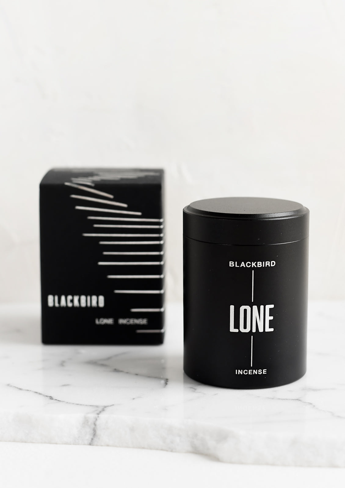 A black incense tin with black and silver packaging.