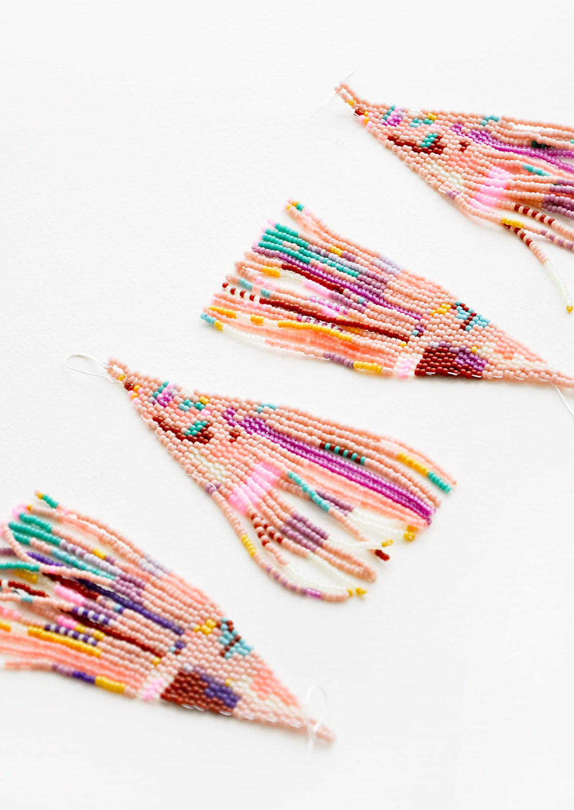 Four pink multicolored beaded fringe earrings.