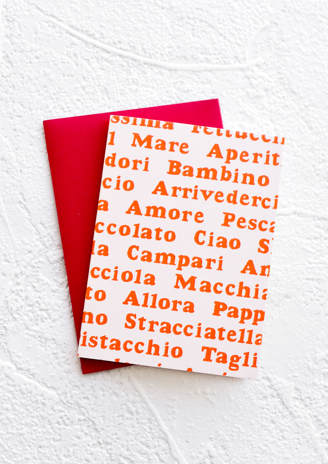 A gift enclosure greeting card with a pale pink background and Italian words printed in red text.