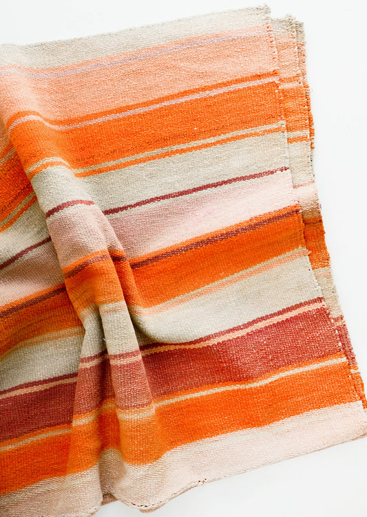 Woven textile intended for use as a rug or blanket, variegated colorful striped pattern.