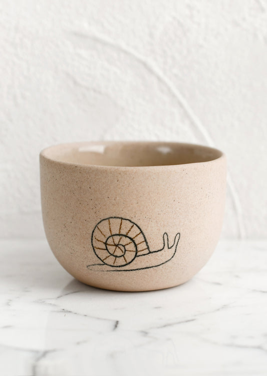 A small sand porcelain cup with snail sketch.