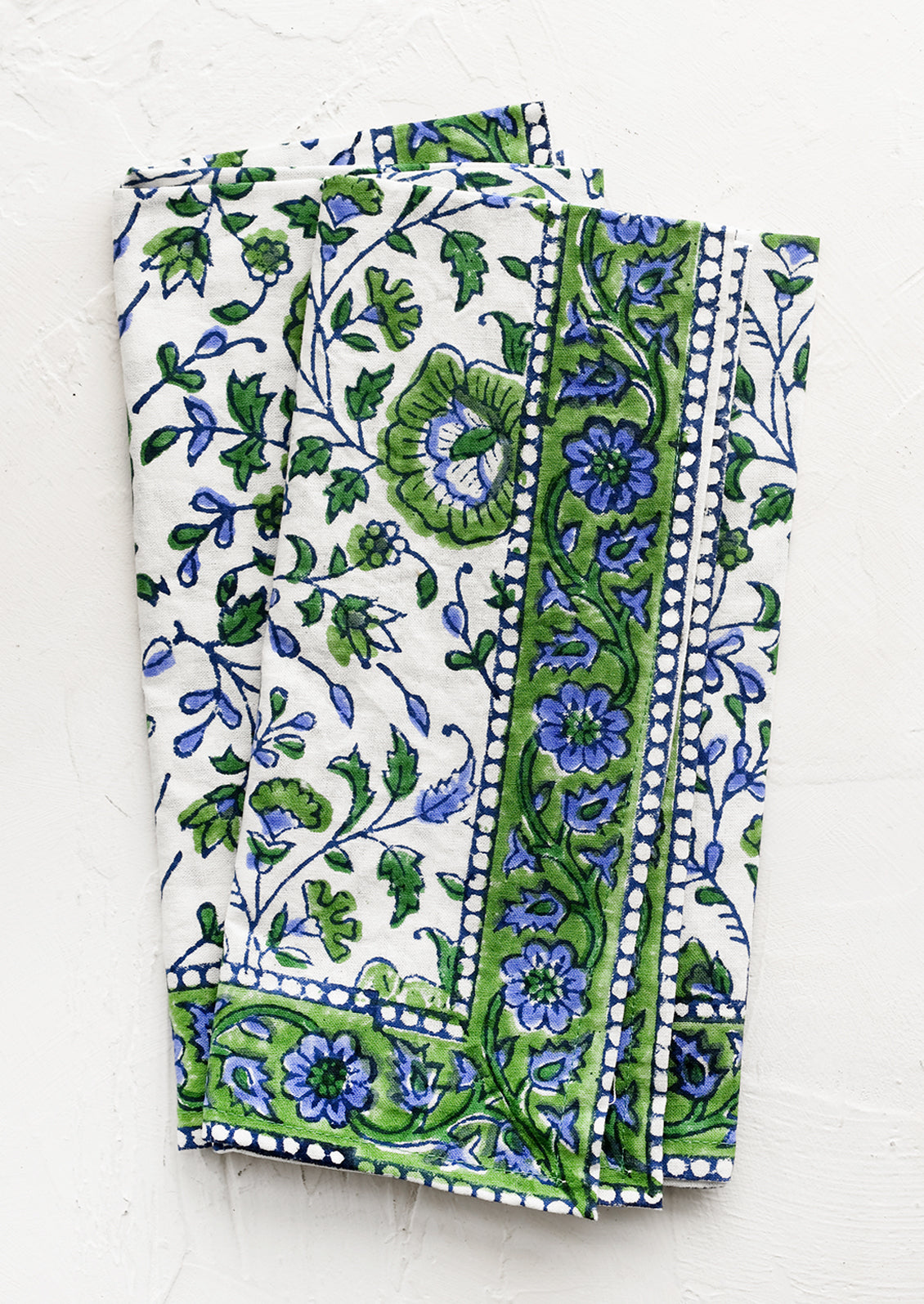 A set of two block printed napkins in blue and green floral print.