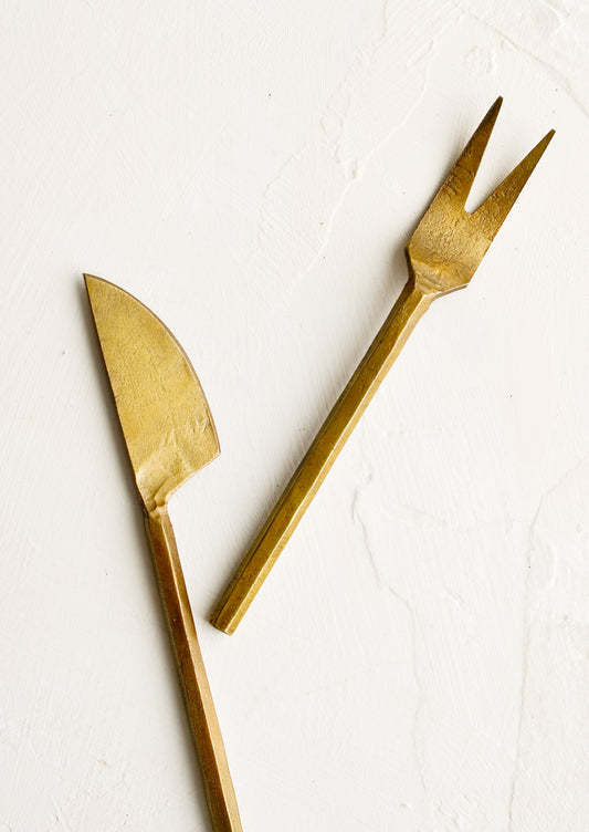 A canape sized fork and knife with primitive inspired shapes in brass.