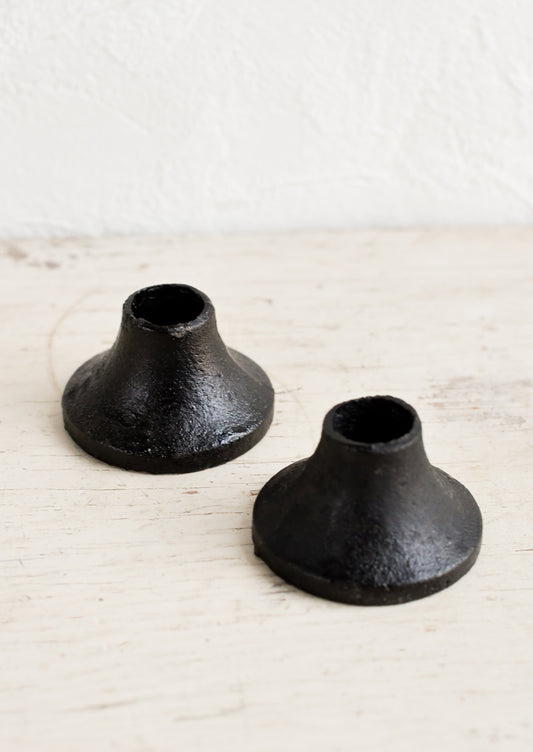 Two ceramic taper candle holders in black cast iron.