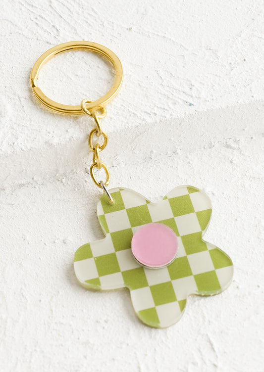 A flower shaped keychain in green checker print with pink center.