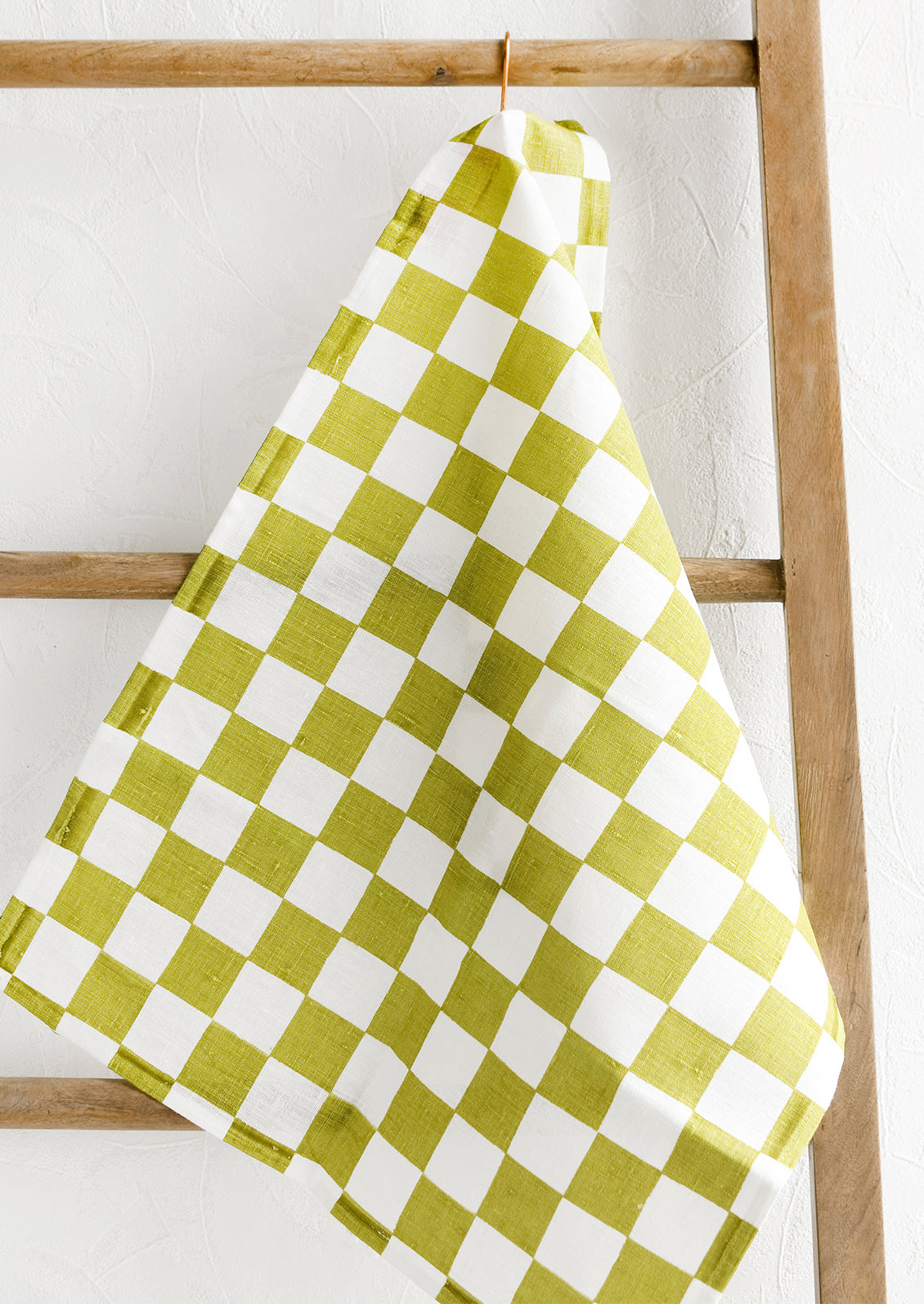 A checkered linen tea towel in green and white.