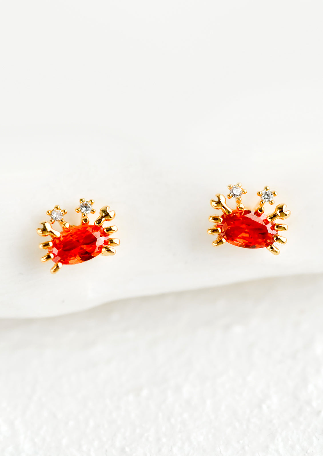 A pair of small stud earrings in the shape of crabs.