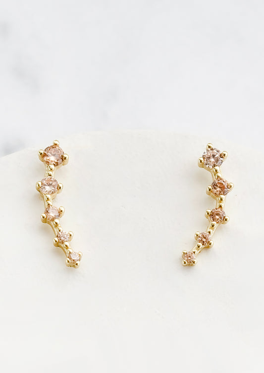 Stud earrings with champagne crystals in incremental sizes, designed to climb up the ear