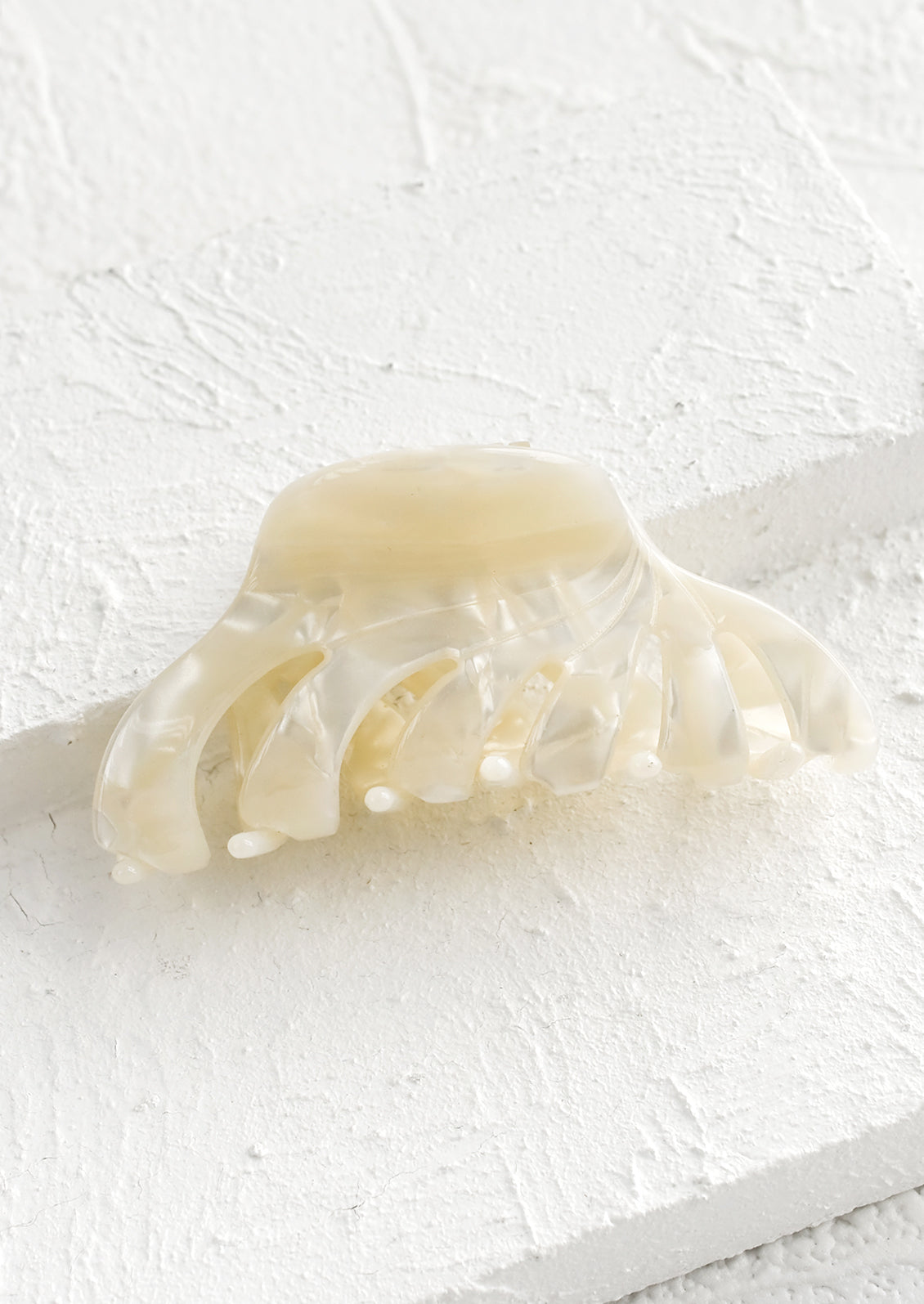 A marbled acetate hair clip in pearl.