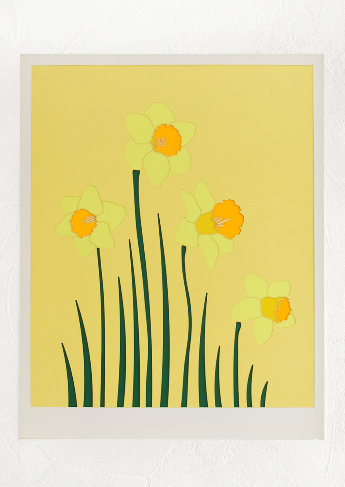 A lasercut artwork depicting daffodils on yellow background.