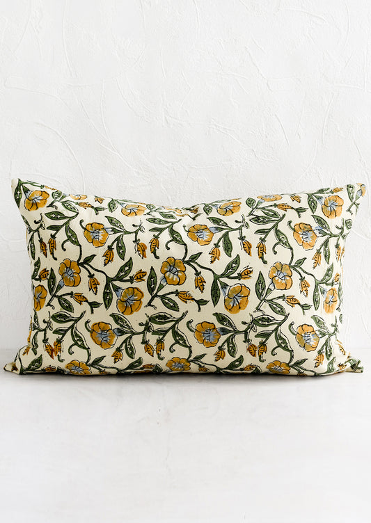 A lumbar pillow in beige, mustard, blue and green floral print.
