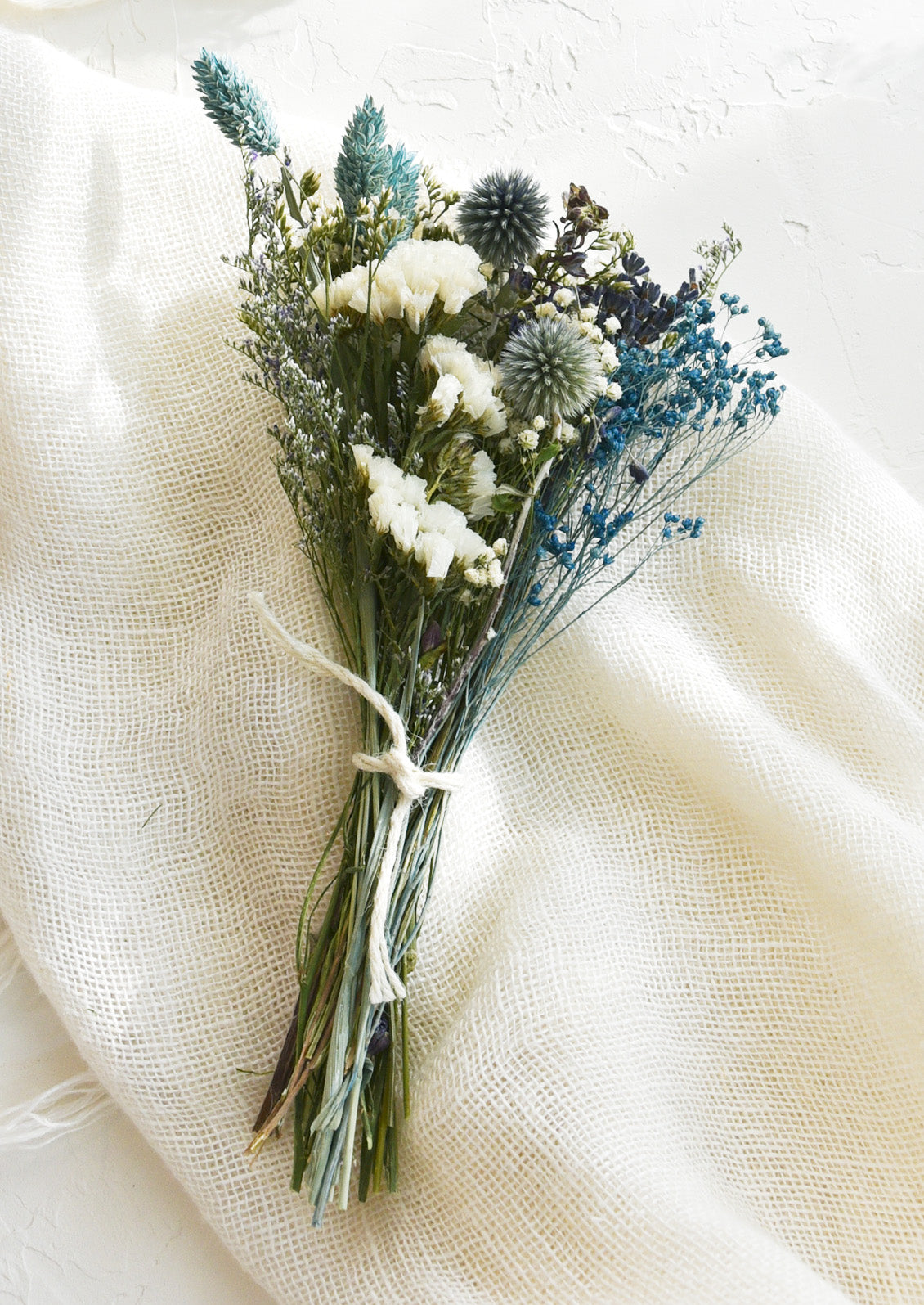 A bouquet of dried flowers in a blue and white mix.