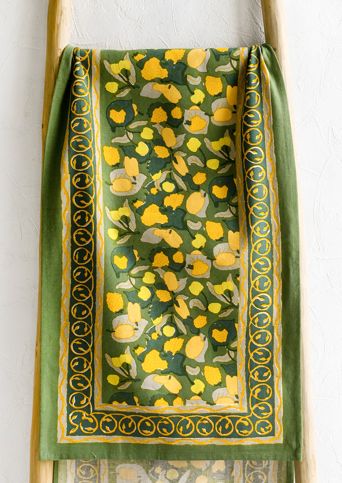 A block printed table runner in green and yellow print.