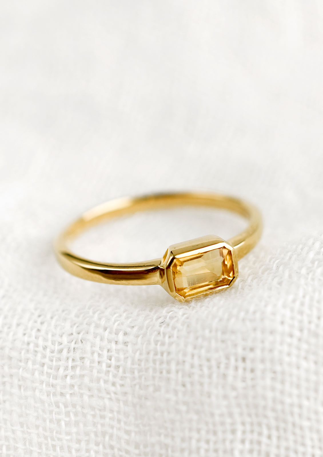 An emerald cut gold ring with citrine stone.