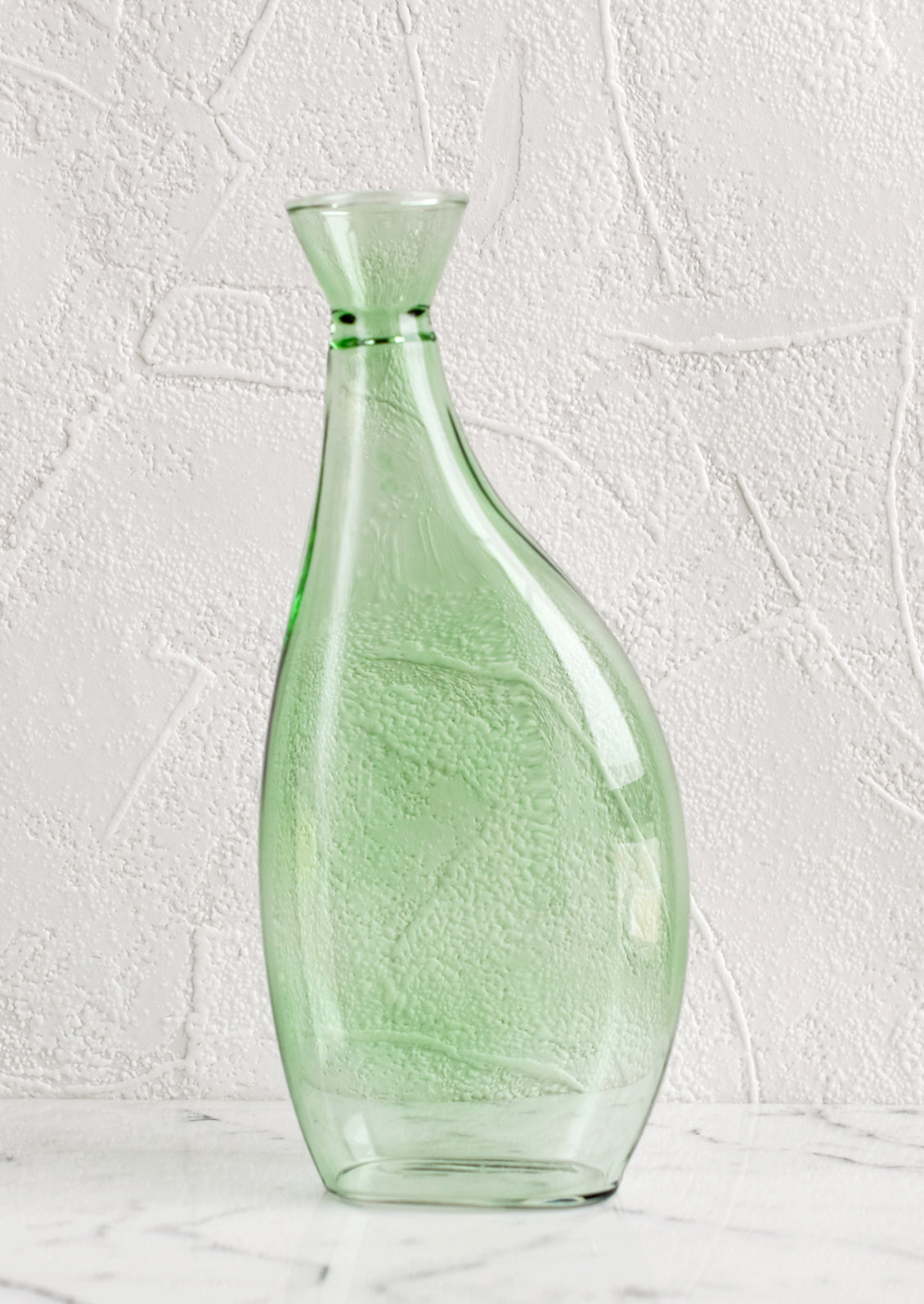 A tall, asymmetric glass vase in translucent green glass.