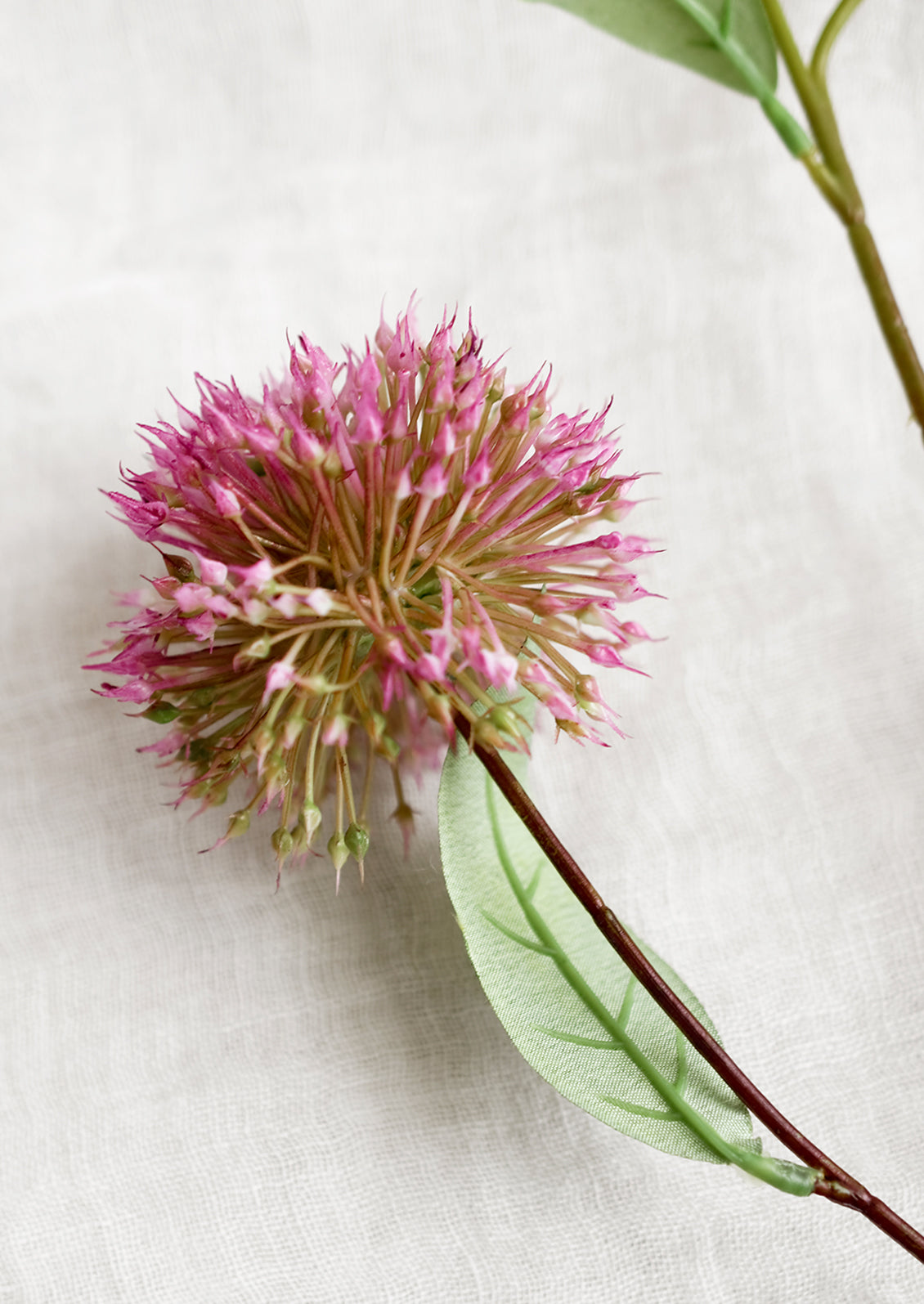 A faux floral spray of allium (onion) flowers.