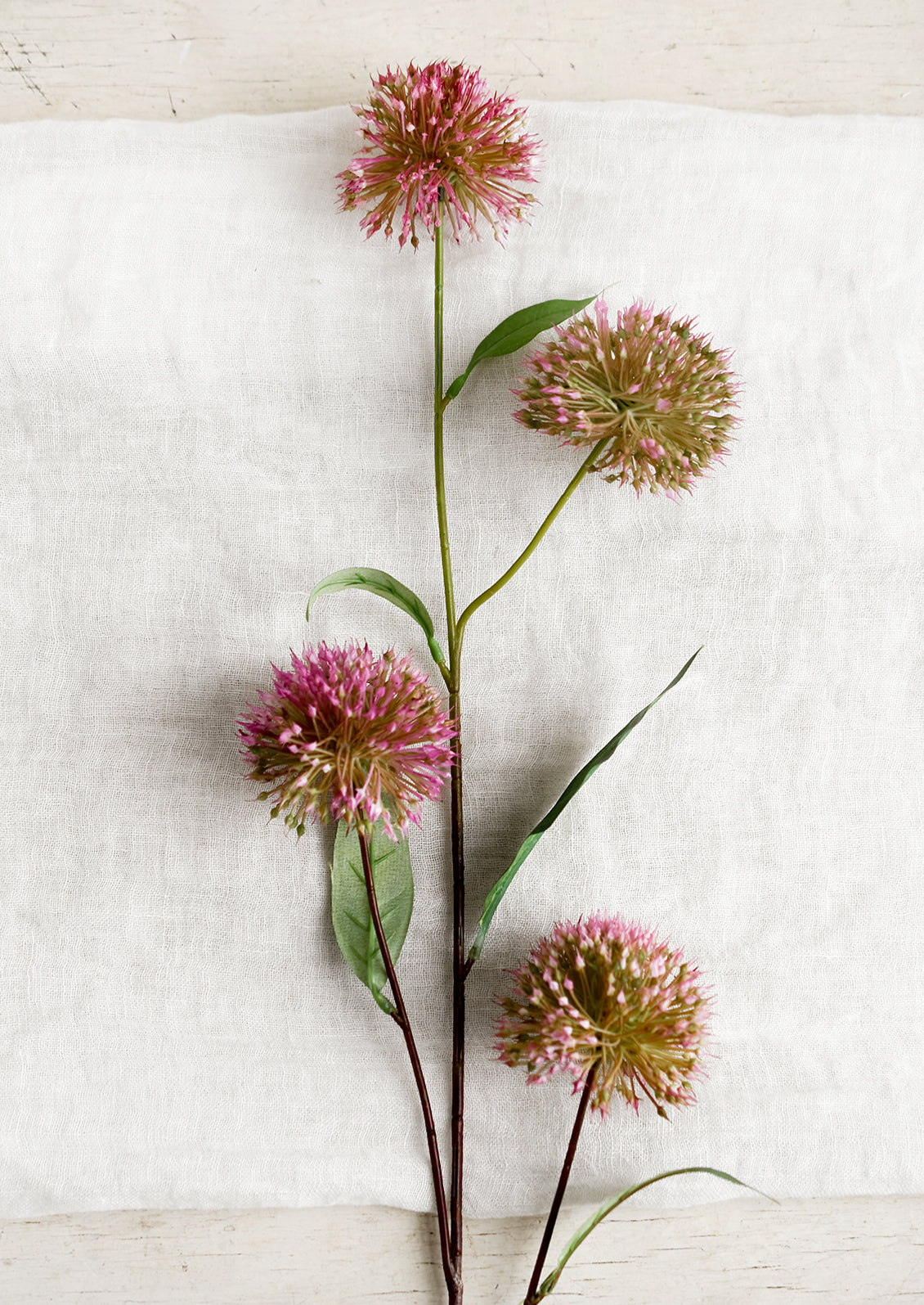 A faux floral spray of allium (onion) flowers.