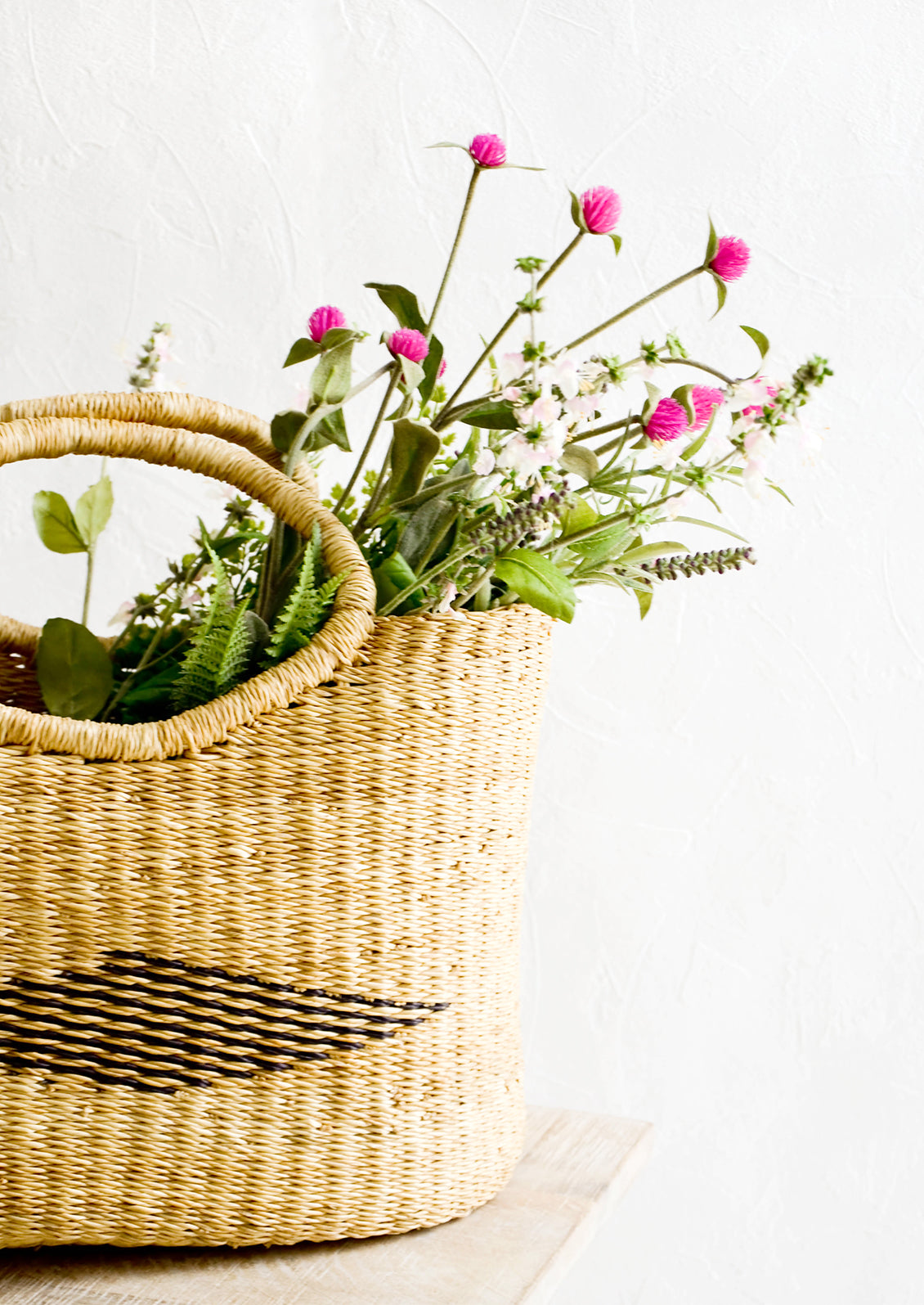 Wildflowers placed inside a woven tote bag made from natural elephant grass